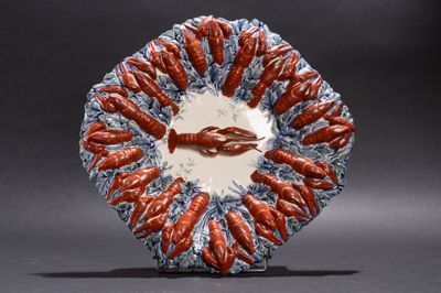 une assiette rouge et blanche sur laquelle sont disposés des homards