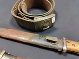 a belt and a knife on a table next to each other