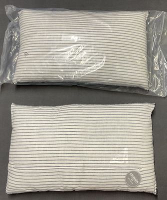 deux sacs contenant des oreillers blancs posés sur une table