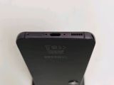 the back of a black cell phone sitting on top of a white table