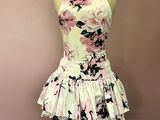 robe à fleurs rose et noire posée sur un présentoir pour mannequin