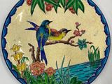 une assiette avec un oiseau et des fleurs