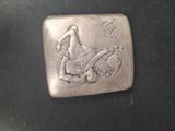 an antique silver belt buckle with a woman on a horse