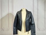 un mannequin vêtu d'une veste en cuir noir, posé sur un pied de mannequin