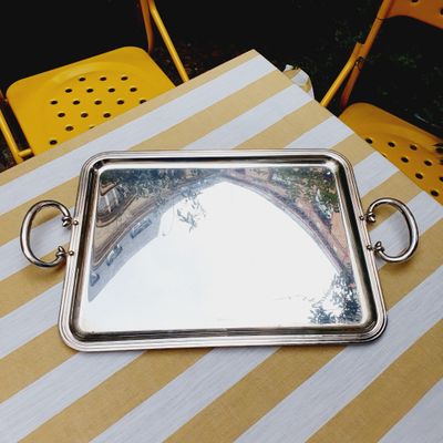 a silver tray on a table with a mirror on it