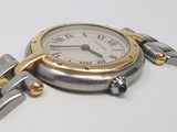 a silver and gold wrist watch with a chain around it