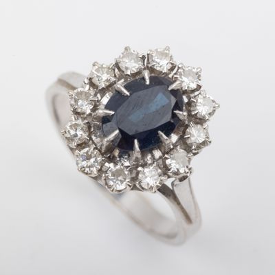 a close up of a ring with a blue sapphire surrounded by white diamonds