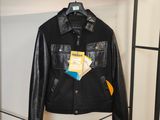 une veste en cuir noir accrochée à un porte-manteau dans une pièce
