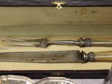 two knives in a box with silverware in it