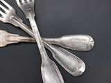 four forks and a spoon on a black surface