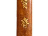 un grand vase en bois orné d'une inscription dorée