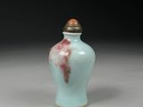 a small blue vase with a brown lid on a table