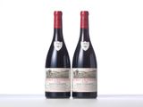 two bottles of red wine sitting on top of a table