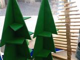 trois sapins de Noël verts exposés dans un magasin
