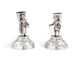 une paire de bougeoirs en argent ornés d'un homme et d'une femme