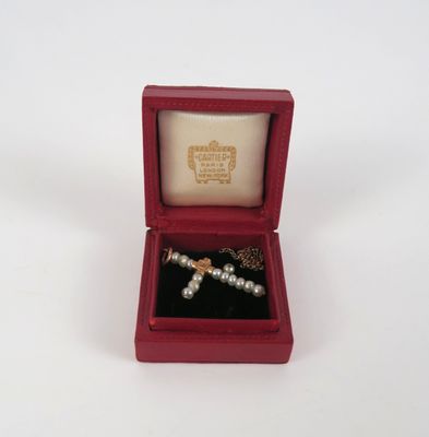 une boîte rouge contenant une croix argentée