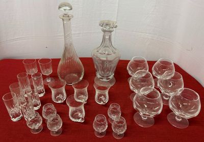 many glasses and a decanter sitting on a red table