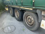 a large green truck that is parked on the side of the road