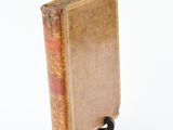 an old book on a small stand on a white surface