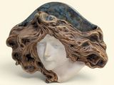 une sculpture représentant la tête d'une femme aux cheveux longs