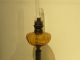 an old fashioned oil lamp sitting on top of a white table