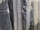 de nombreux matelas emballés dans des sacs en plastique dans un entrepôt