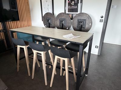 quatre tabourets disposés autour d'une table au milieu d'une pièce