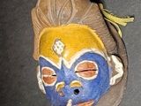 a blue and yellow mask on a black surface