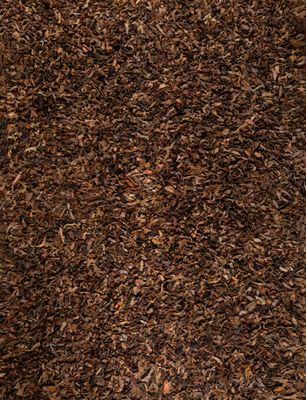 tapis à poils longs marron sur lequel est déposé un tas de feuilles