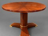 une table de salle à manger ronde avec un plateau en bois et des finitions en laiton