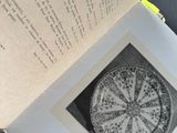 an open book with a picture of a circular design on it