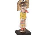 an image of a wooden statue of a woman with a bird on her head