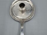 an antique silver plate with a candle holder on top of it