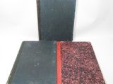 un vieux livre posé sur une table blanche à côté d'un livre noir