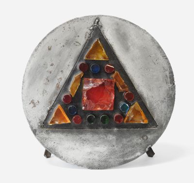 une image représentant une assiette en argent sur laquelle est posé un triangle en verre