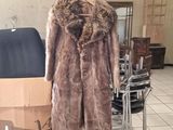 a fur coat on a mannequin stand in a room