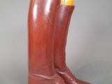pair of brown leather cowboy boots with yellow soles on a gray background