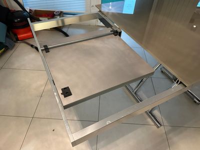 a stainless steel table with a drawer underneath it