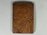 un gros plan sur une plaque en bois sur laquelle est représenté un soleil