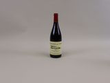 une bouteille de vin rouge posée sur une table blanche