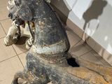 a wooden horse that is sitting on a tile floor