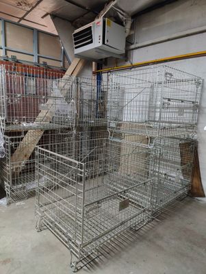 a man standing next to a cage filled with animals