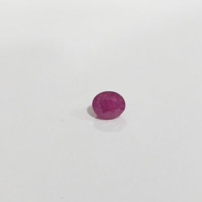 gros plan d'une pierre rose sur une surface blanche