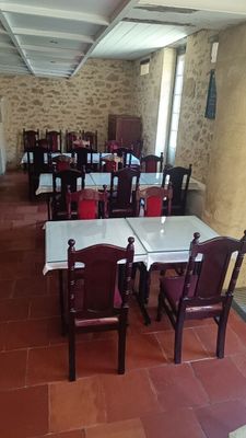 de nombreuses tables et chaises dans un restaurant au sol carrelé de rouge