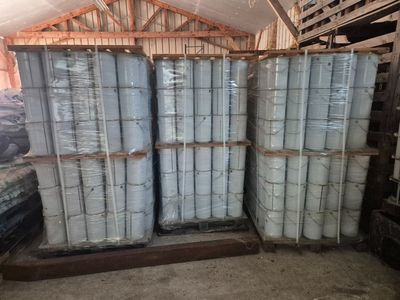 Plusieurs piles de palettes sont empilées les unes sur les autres dans un entrepôt