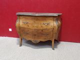 a small chest of drawers in a room with a red wall