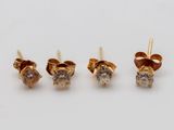 trois paires de boucles d'oreilles en diamant posées sur une surface blanche