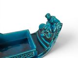 a blue and black boat with a man on it