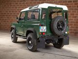 a green and white land rover parked in front of a brick wall