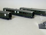trois trains miniatures posés les uns à côté des autres sur une table